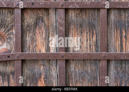 Close up of old wooden door with  wrought iron bars Stock Photo