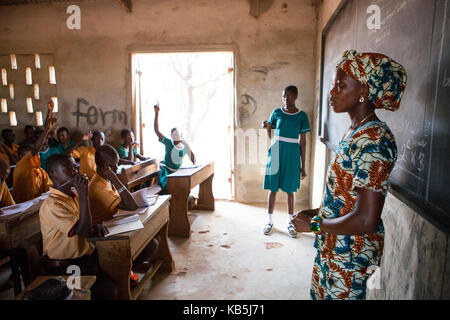 A female teacher teaching at the front of the classroom at a primary school in Ghana, West Africa, Africa Stock Photo