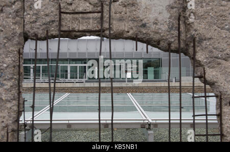 Berlin, Germany. 26th Sep, 2017. The visitor center on the grounds of the memorial site Topographie des Terrors can be seen through a hole in the former border wall in Berlin, Germany, 26 September 2017. The online service TripAdvisor named the facility the best museum of Germany. The Topographie des Terrors is also the most visited museum of the city with 1.3 million visitors per year. Credit: Paul Zinken/dpa/Alamy Live News Stock Photo