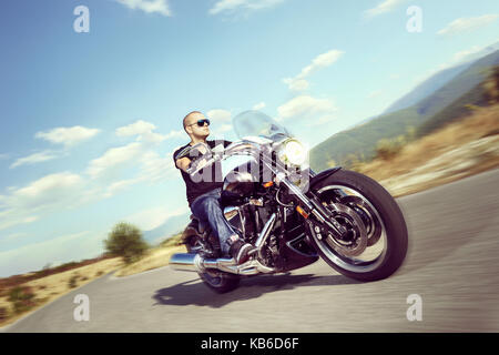 Guy riding a motorcycle on an open road Stock Photo