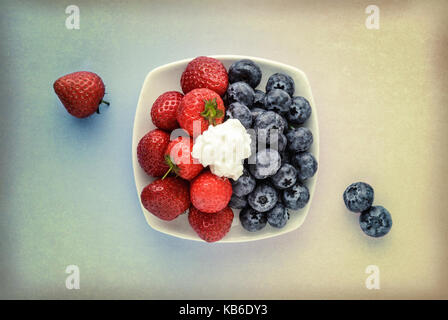 Strawberries and Blueberries in white bowl with a texture overlay Stock Photo