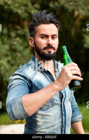 Hipster man with beard drinking a beer Stock Photo