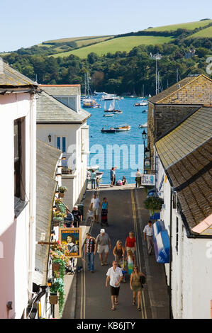 Looking down past the Fortescue Inn public house in  Salcombe - South Devon towards the estuary with tourists walking down the street. Seafood Coast Stock Photo