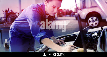 Mechanic using laptop on car at the repair garage Stock Photo