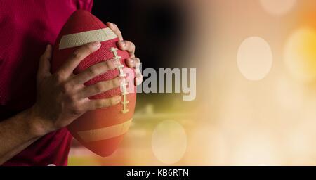 Digital composite of American football in hands with stadium transition Stock Photo