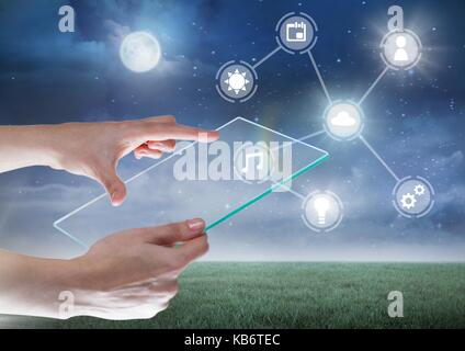 Digital composite of Hand holding glass tablet with icons interface of internet of things Stock Photo
