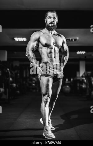 Athlete muscular bodybuilder man posing in gym. Stock Photo