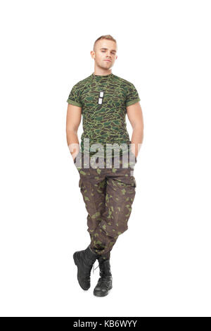 Full length portrait of young army soldier standing with hands in pockets isolated on white background Stock Photo