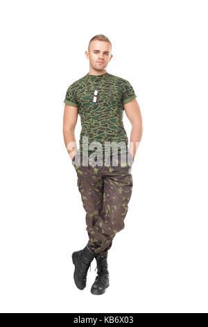 Full length portrait of young army soldier standing with hands in pockets isolated on white background Stock Photo