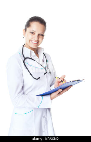 Portrait of young smiling female doctor writing on clipboard isolated on white background Stock Photo