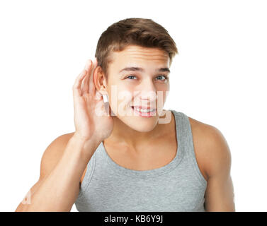 Young man with hand on ear listening carefully isolated on white background Stock Photo