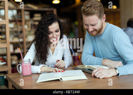 Young students spending time in coffee shop reading books Stock Photo