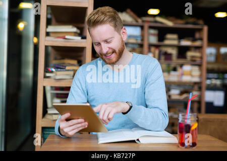 Young man using digital tablet in coffee shop Stock Photo