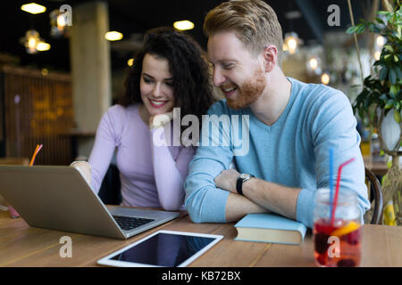 Happy couple spending time at coffee shop working on laptop Stock Photo