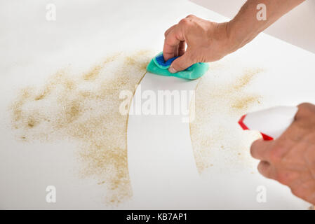 Cropped image of male janitor cleaning counter with detergent spray bottle and sponge Stock Photo