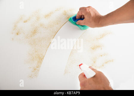 Cropped image of male janitor cleaning counter with detergent spray bottle and sponge Stock Photo