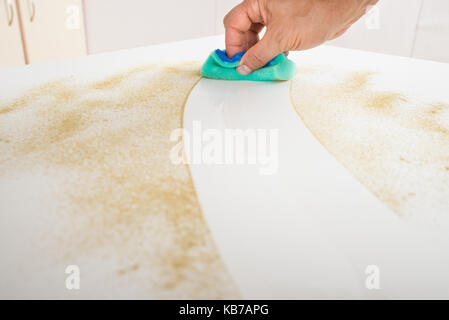 Cropped image of male janitor cleaning counter with detergent spray bottle and sponge Stock Photo