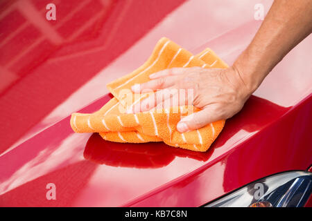 Cropped image of male worker washing red car hood Stock Photo
