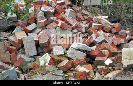A pile of old clay bricks. Stack of rubble after demolition. Stock Photo