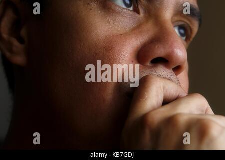 Photo of a man with his hand on his mouth and chin Stock Photo