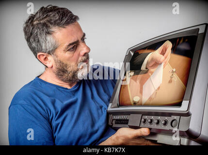 Man with surprised face looking at a television vintage Spanish elections Stock Photo