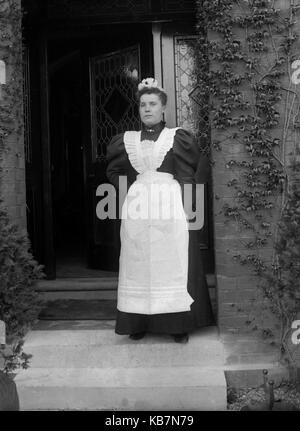 AJAXNETPHOTO. 1890 - 1914 (APPROX). LOCATION UNKNOWN. - HOUSE MAID POSING FOR CAMERA ON DOORSTEP OF HOUSE. PHOTOGRAPHER:UNKNOWN © DIGITAL IMAGE COPYRIGHT AJAX VINTAGE PICTURE LIBRARY SOURCE: AJAX VINTAGE PICTURE LIBRARY COLLECTION REF:AVL 172109 4 Stock Photo