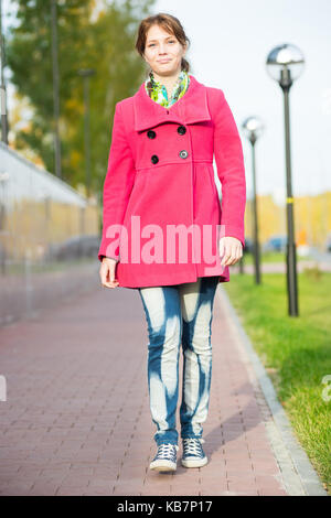 Beautiful woman in red coat walking autumn street.  Stock Photo