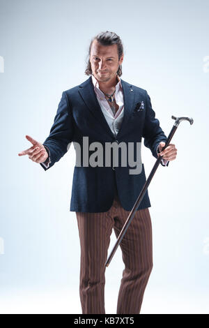 The mature barded man in a suit holding cane. Stock Photo