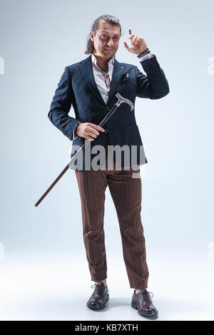 The mature barded man in a suit holding cane. Stock Photo