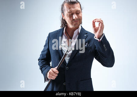 The mature barded man in a suit holding cane. Stock Photo