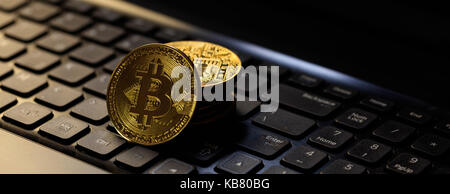 Golden bitcoins on a black computer keyboard Stock Photo