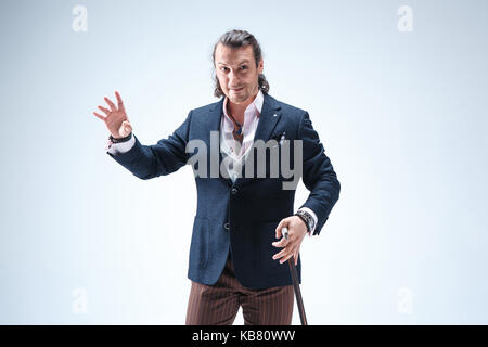 The mature barded man in a suit holding cane. Stock Photo