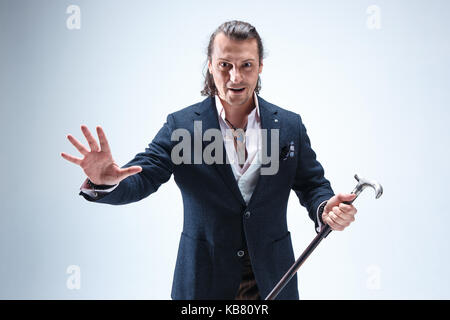 The mature barded man in a suit holding cane. Stock Photo