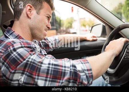 Irritated young man driving a car. Irritated driver Stock Photo