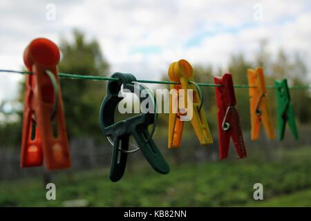 Different shaped colorful clothespins hanging on the clothesline. Stock Photo