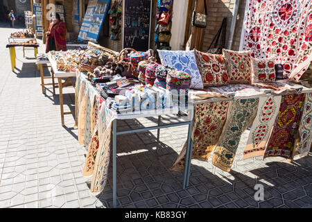 BUKHARA, UZBEKISTAN - OCTOBER 19, 2016: Uzbek souvenirs. Female saleswoman sells handicrafts on the streets of Bukhara Stock Photo