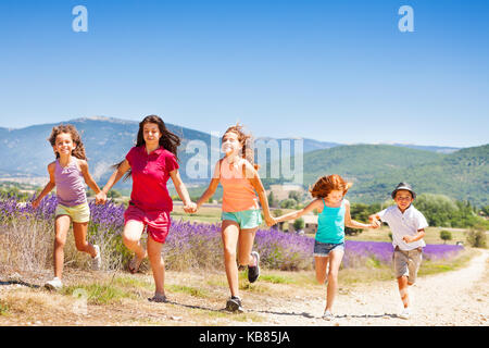 Happy kids running together through lavender field Stock Photo