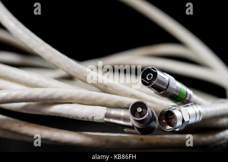 Old entangled cables, electronics and old cable connectors on a black table. Black background Stock Photo