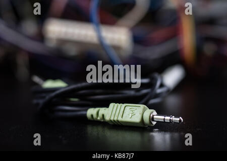 Old entangled cables, electronics and old cable connectors on a black table. Black background Stock Photo