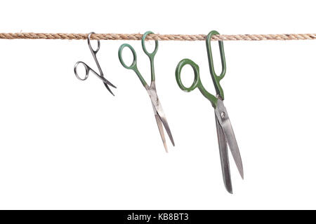 Three scissors hanging on a rope isolated on white background Stock Photo