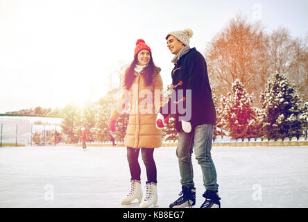 happy couple ice skating on rink outdoors Stock Photo