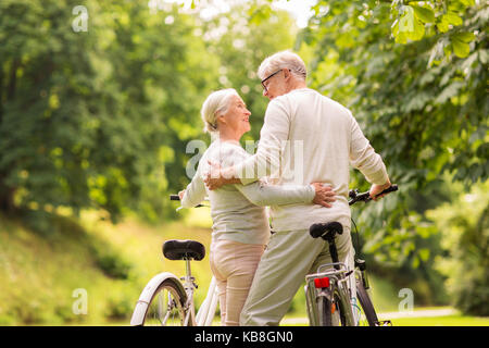 happy senior couple with bicycles at summer park Stock Photo