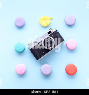delicious French dessert macarons with vintage camera on a blue background Stock Photo