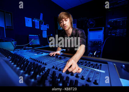 Man using a sound mixing desk in a recording studio Stock Photo
