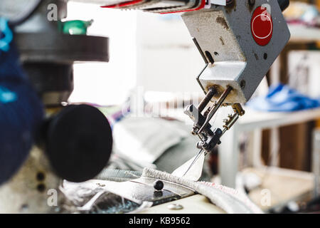 Overlock sewing machine - view on working area and machine front with needle - foreground blanked ot blurry. Stock Photo