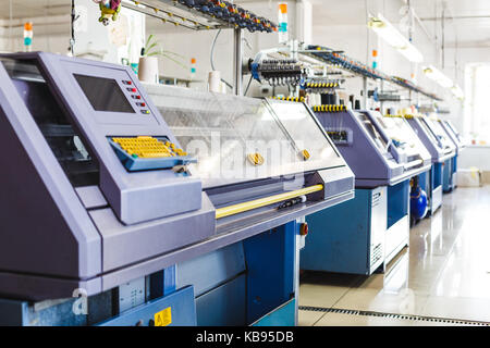 Textile industry with knitting machines in factory. Knitting and weaving machines in textile industry Stock Photo