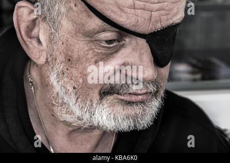 Cropped portrait of a bearded senior man with eye patches Stock Photo