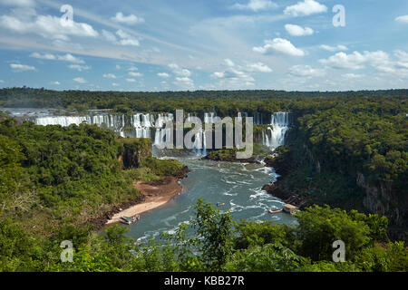 Iguazu Falls on Argentina side, and tourist boats on Iguazu River, Brazil - Argentina Border, South America Stock Photo