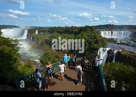 Tourists on viewing platform on Brazil side of Iguazu Falls, looking at Argentinian  side, South America Stock Photo