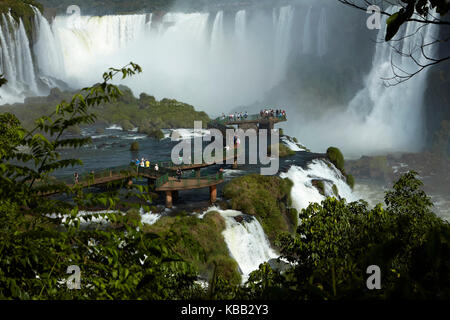 Tourists on viewing platform on Brazil side of Iguazu Falls, Brazil - Argentina border, South America Stock Photo